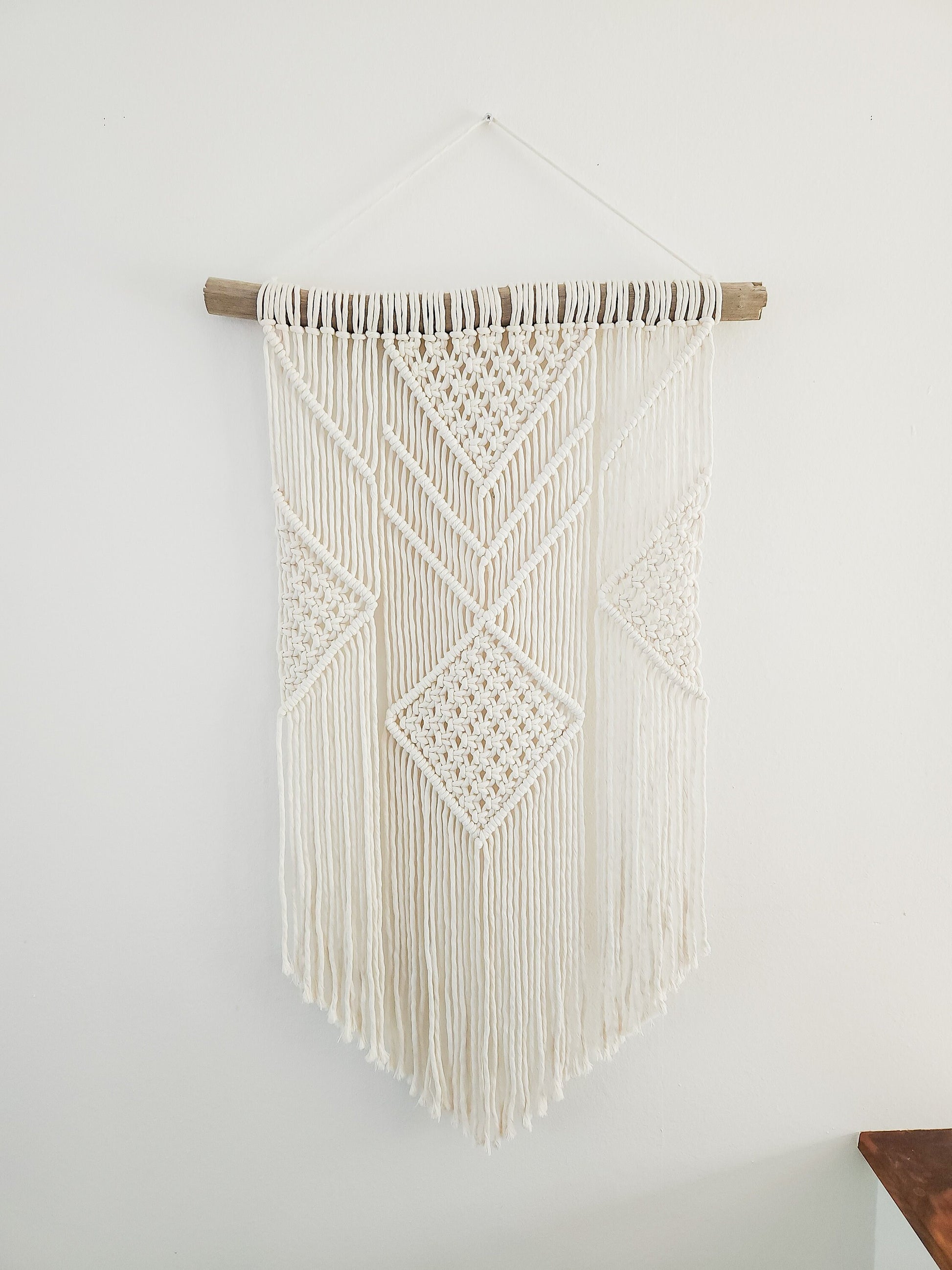Beige (off white) macrame wall hanging on driftwood