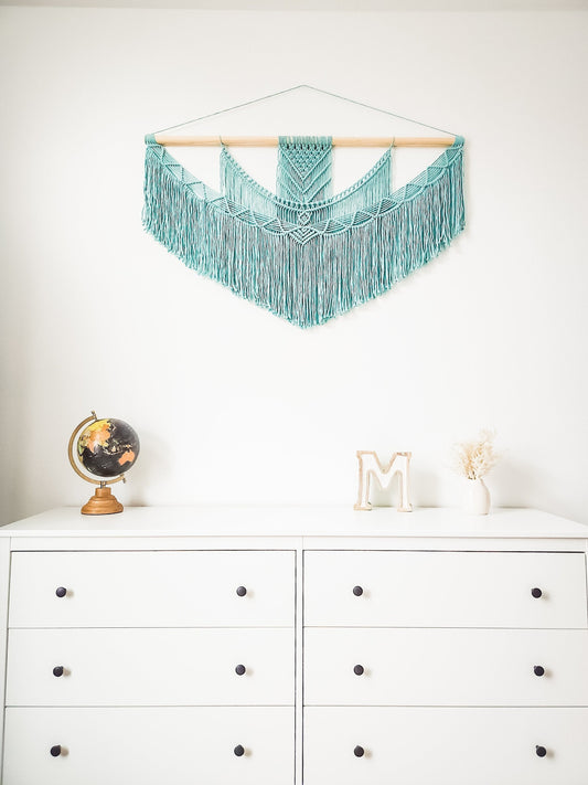 This is a turquoise blue macrame wall hanging on a piece of wood rod. It comes in 5 different sizes.